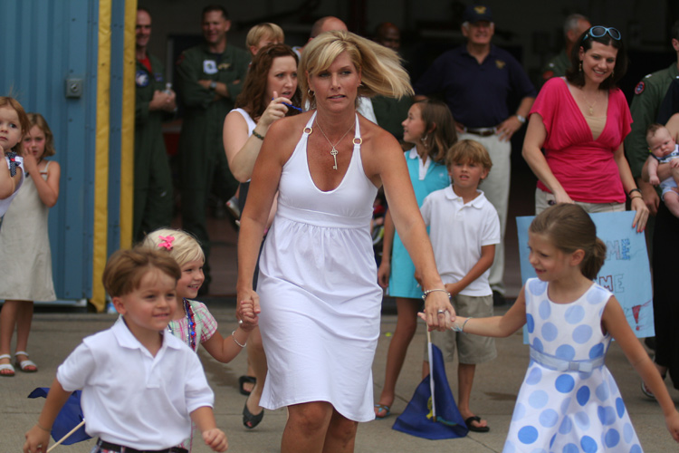 Cristin Hewlett, along with her daughters, Emma (L) and Riley (R) run out to the flightline to greet VFA-131 Executive Officer Commander Ben Hewlett during the Wildcat's homecoming at NAS Oceana July 29. Also heading out to the flightline to greet his dad is 4 year old Nathan Ballou, son of the VFA-131 Maintenance Officer, Lt. Commander Nathan Ballou. © Mike Lynaugh