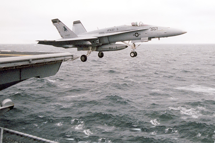 An F-18 Hornet from VFA-37 "The Bulls" roars off the flight deck of the U.S.S. Enterprise, CVN-65, into a rainy sky out in the Atlantic Ocean. �  � Mike Lynaugh