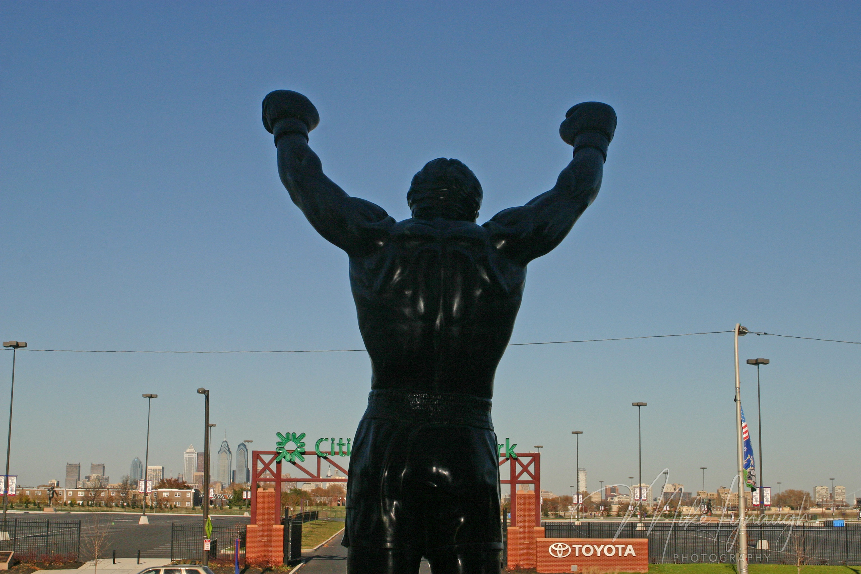 The Rocky statue photographed from in front of the Philadelphia Spectrum arena as seen from behind.