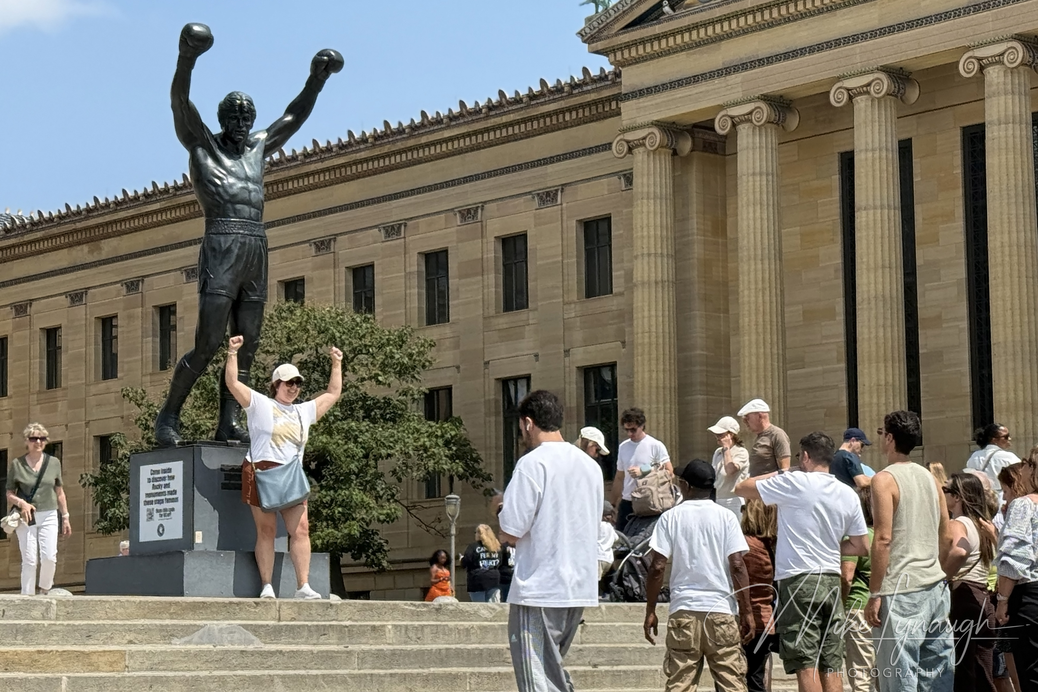 Rocky Statue — Visitors strike a pose with the Rocky Statue. Visitors wait in line to snap a picture posing next to the iconic Rocky statue.
