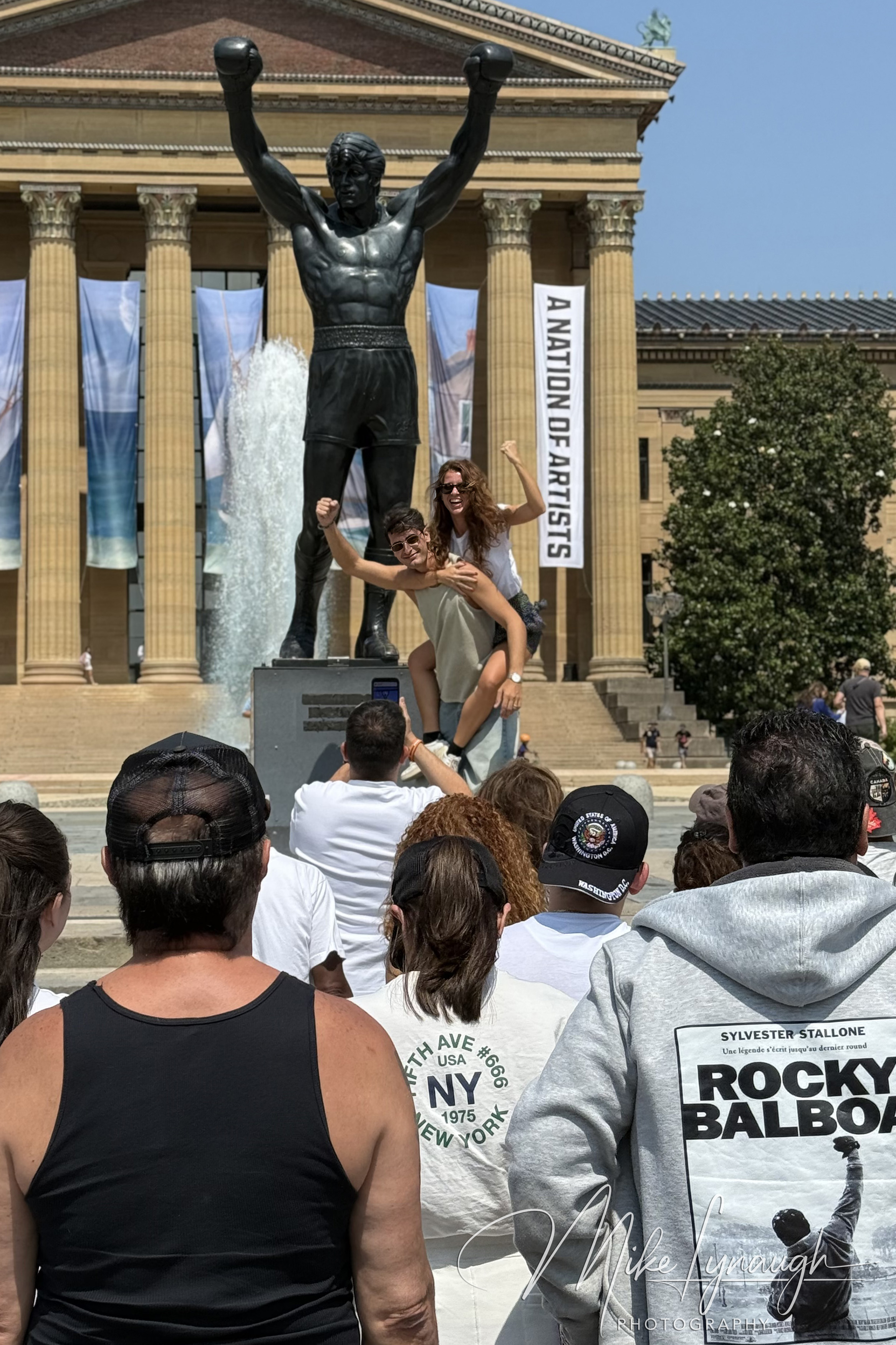 A couple strike a fun pose while capturing a special memory in front of the iconic Rocky Statue.