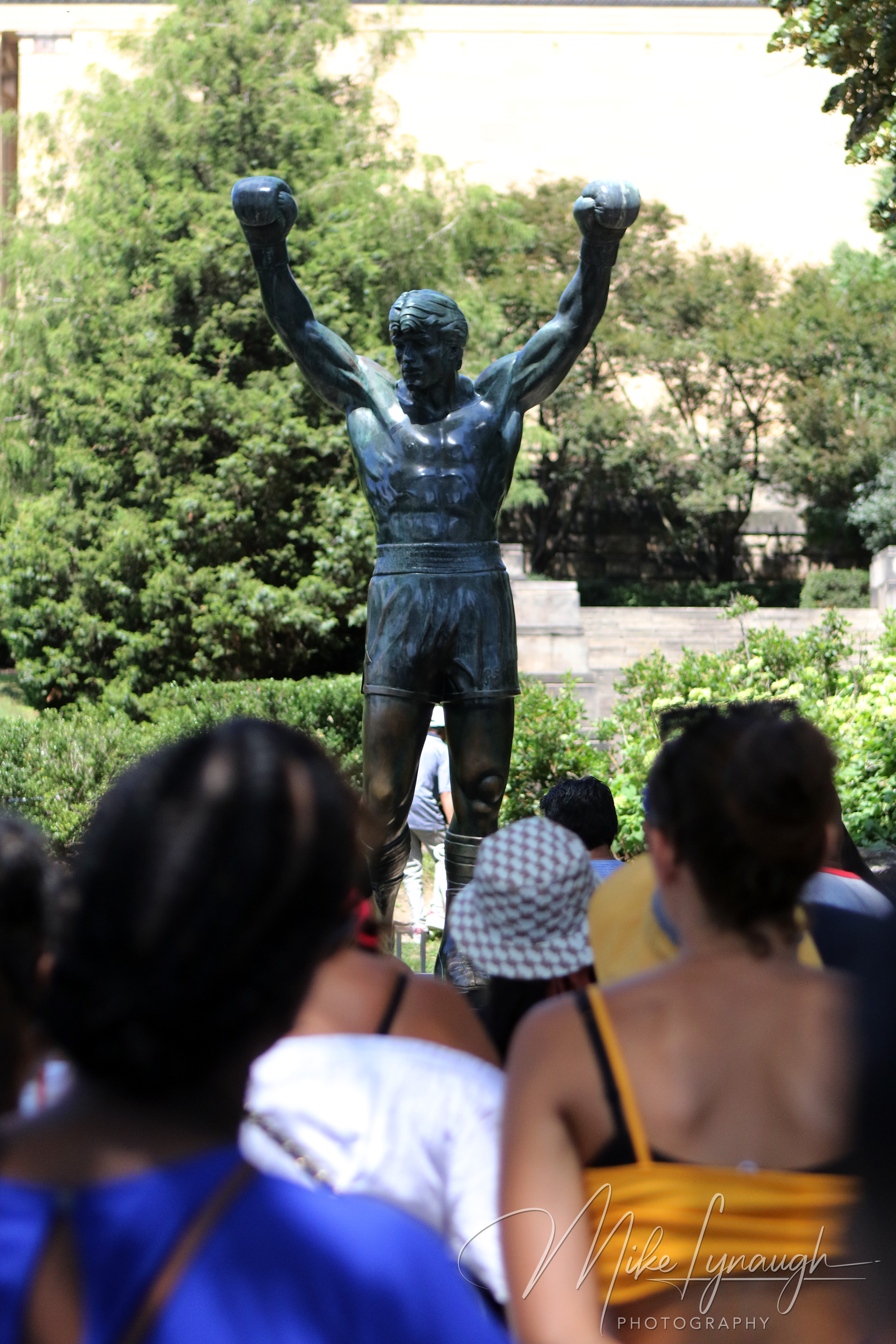 Rocky Statue — Visitors strike a pose with the Rocky Statue. Visitors wait in line to snap a picture posing next to the iconic Rocky statue.
