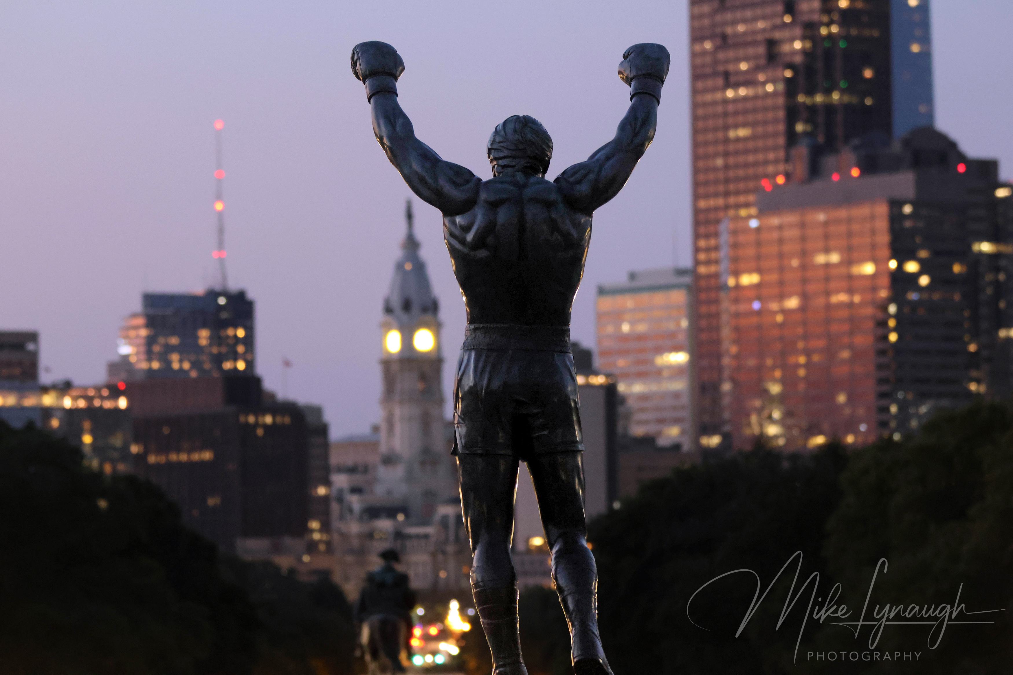 Rocky Statue — Sunrise at the Philadelphia Museum of Art and Skyline. Sylvester Stallone's personal Rocky Statue overlooks the Philadelphia skyline as the morning light begins to illuminate the city.