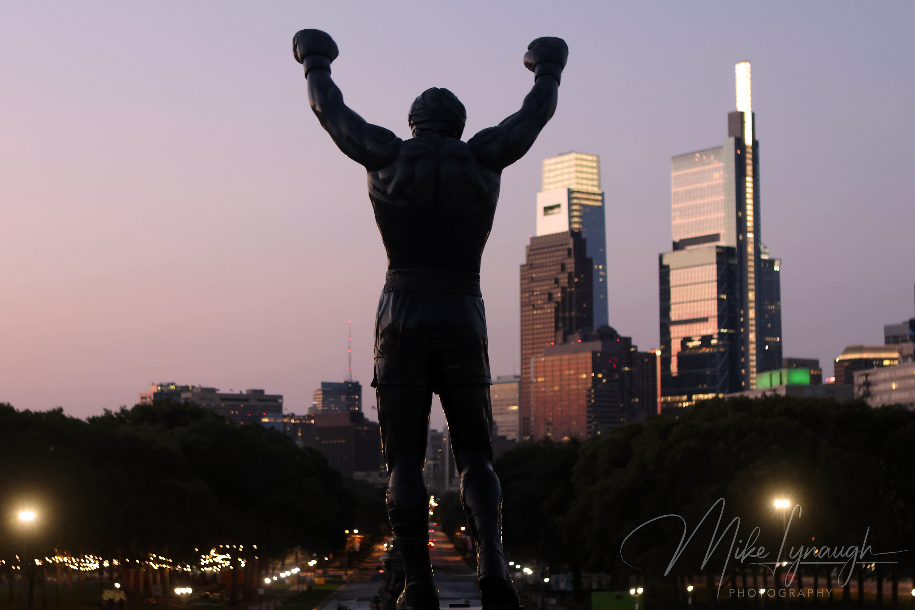 Rocky Statue — Sunrise at the Philadelphia Museum of Art and Skyline. Sylvester Stallone's personal Rocky Statue overlooks the Philadelphia skyline as the morning light begins to illuminate the city.
