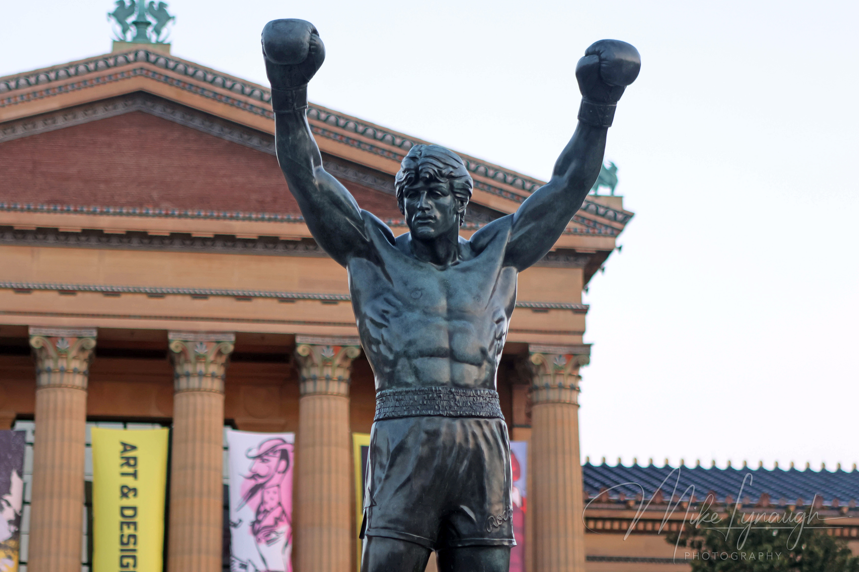 The Rocky statue photographed in front of the main entrance to the Philadelphia Museum of Art at the top of the iconic Rocky Steps.
