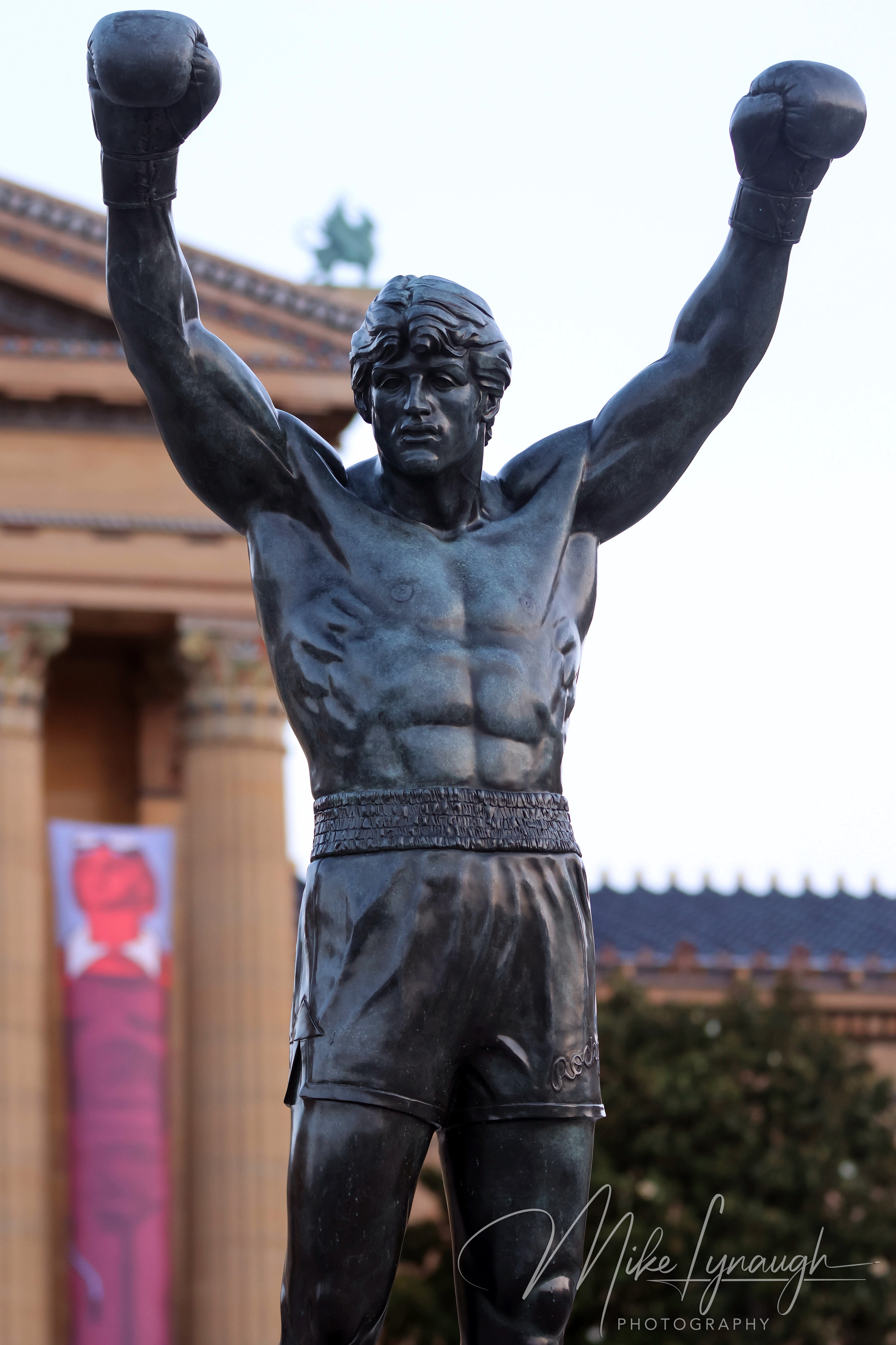The Rocky statue photographed in front of the main entrance to the Philadelphia Museum of Art at the top of the iconic Rocky Steps.