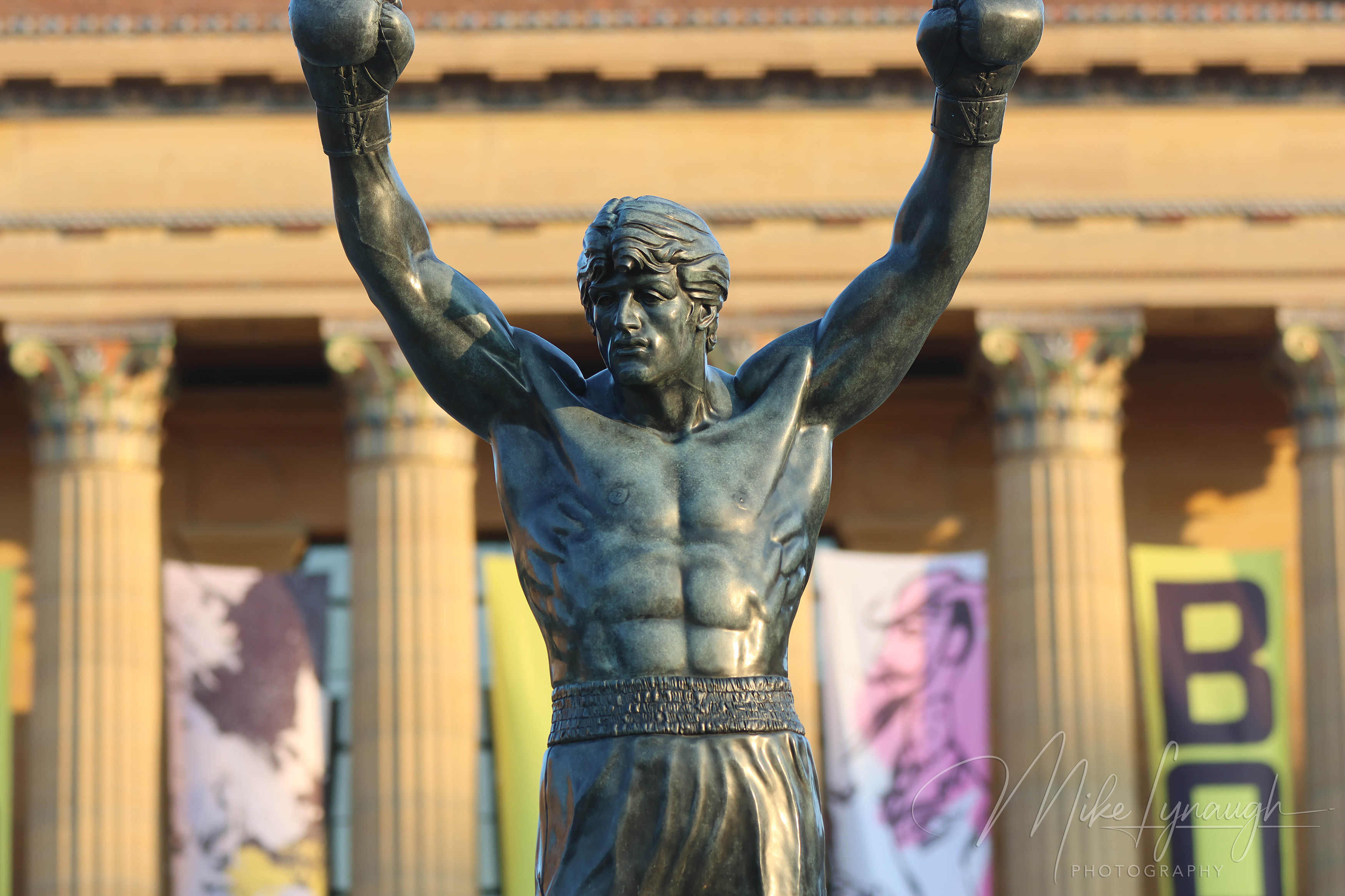 Rocky Statue — Sunrise illuminates the Rocky Statue at the top of the Rocky Steps. Sylvester Stallone's personal Rocky Statue photographed in front of the pillars of the main entrance to the Philadelphia Museum of Art.