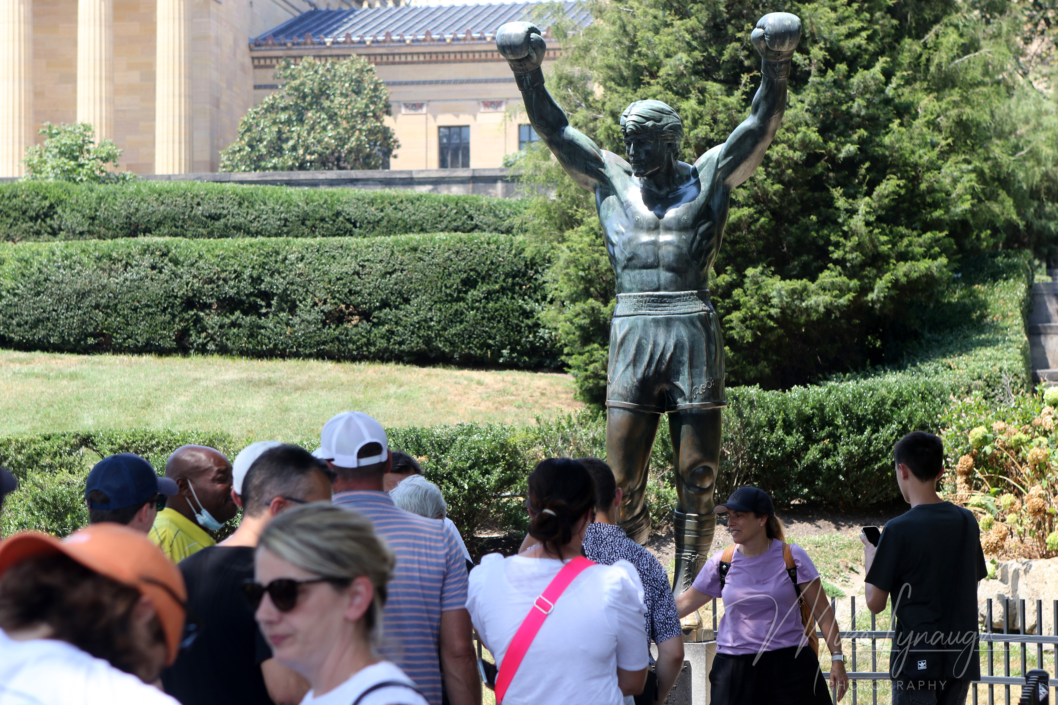 Rocky Statue — Visitors strike a pose with the Rocky Statue. Visitors wait in line to snap a picture posing next to the iconic Rocky statue.