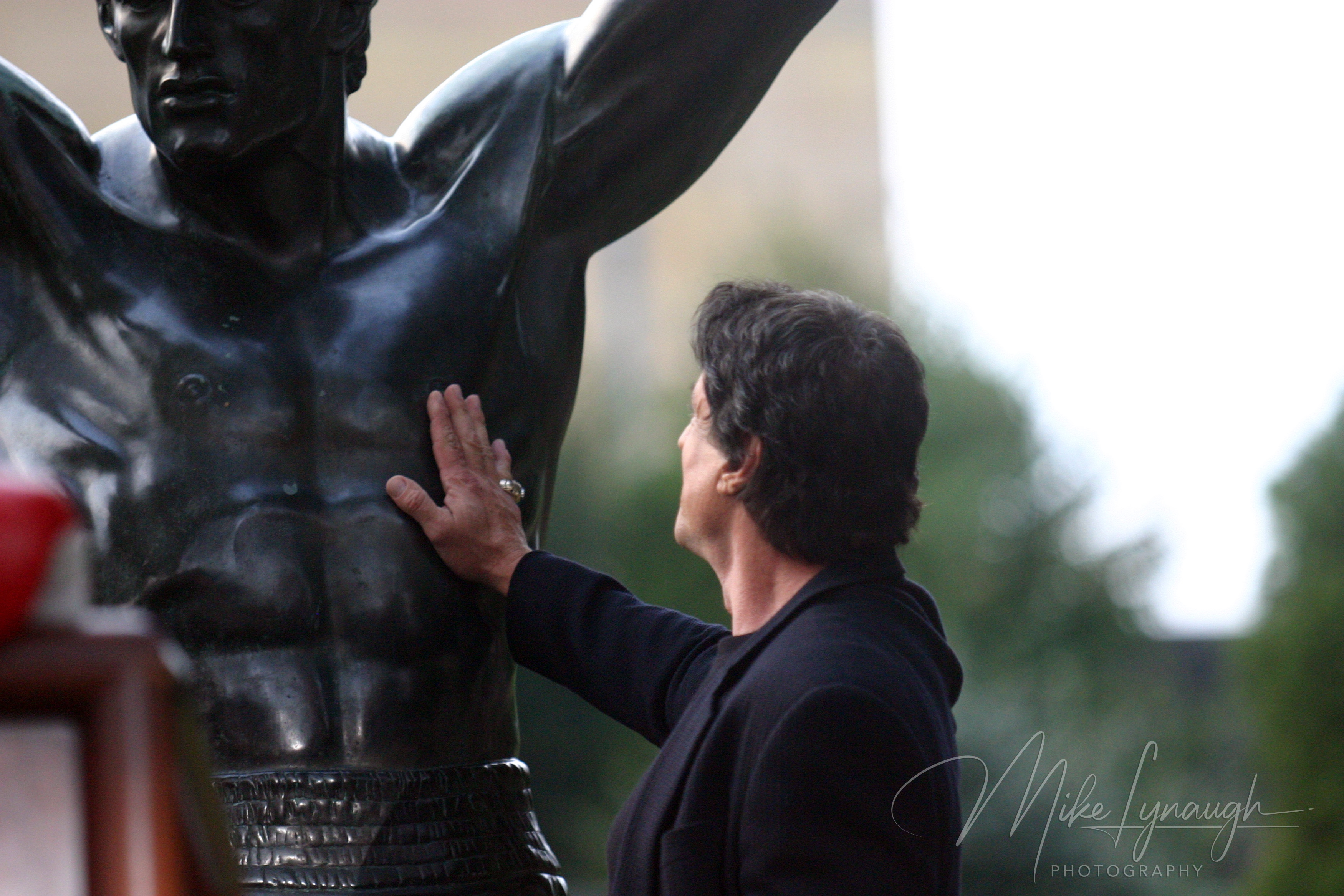 Sylvester Stallone places his hand on the Rocky Statue following his speech at the rededication of the statue at the base of the Rocky Steps at the Philadelphia Museum of Art.