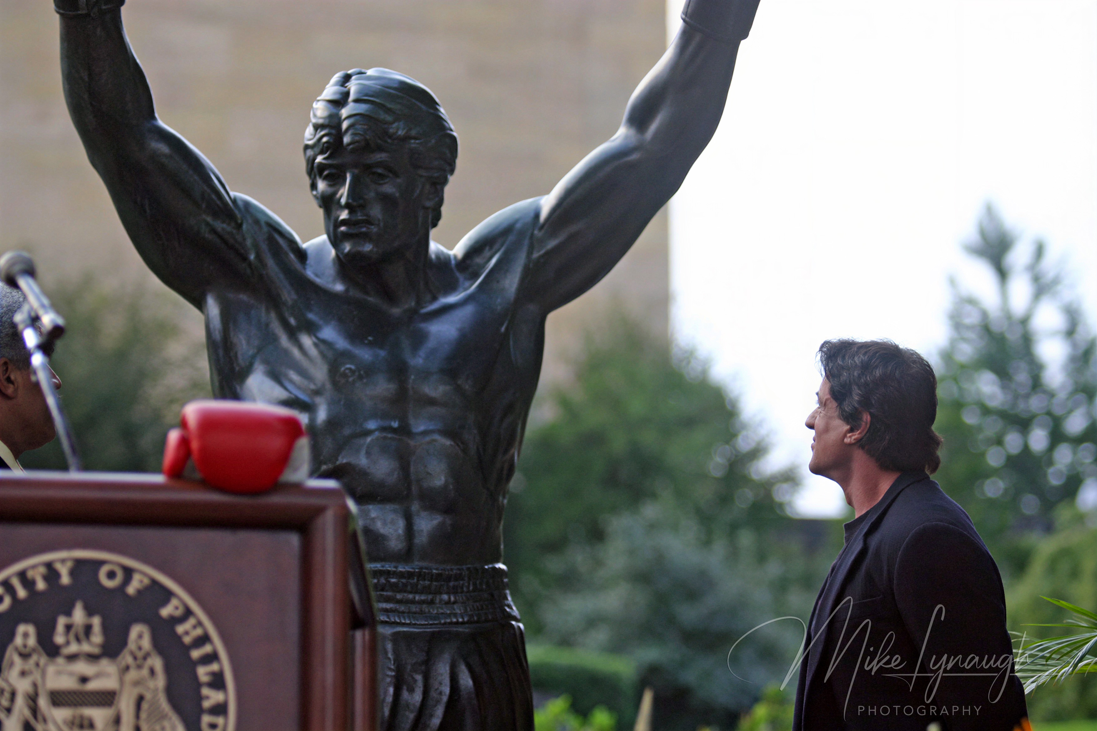 Sylvester Stallone enjoys the moment with the Rocky Statue following his speech at the rededication of the statue at the base of the Rocky Steps at the Philadelphia Museum of Art.