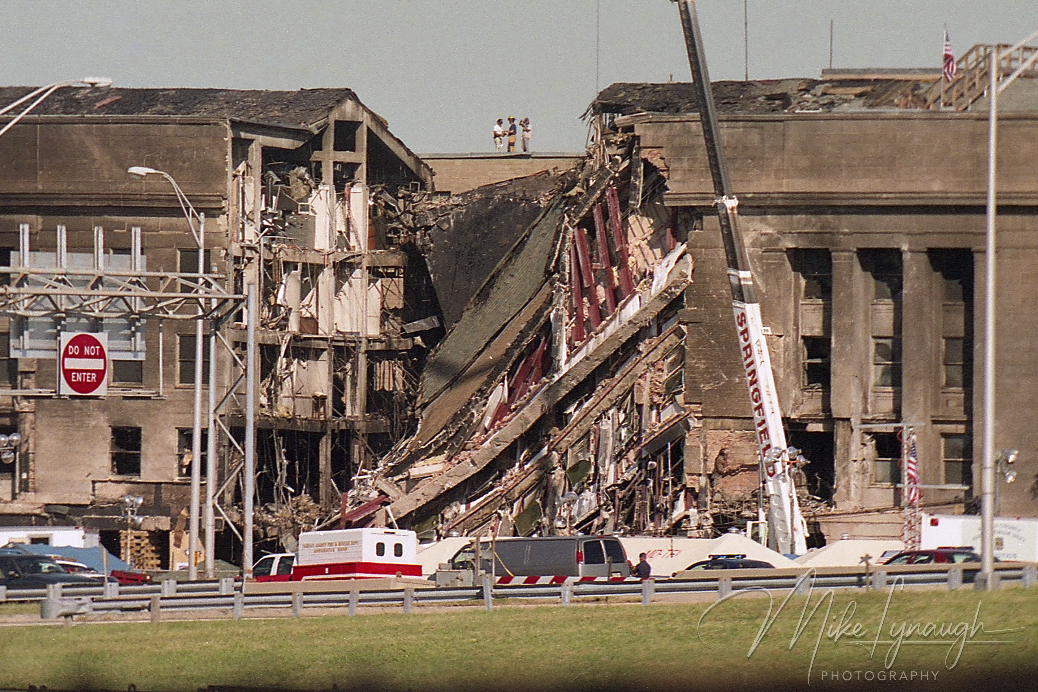 Detailed photo of first responders standing on the roof of the Pentagon directly above the collapsed wall section on September 12 2001