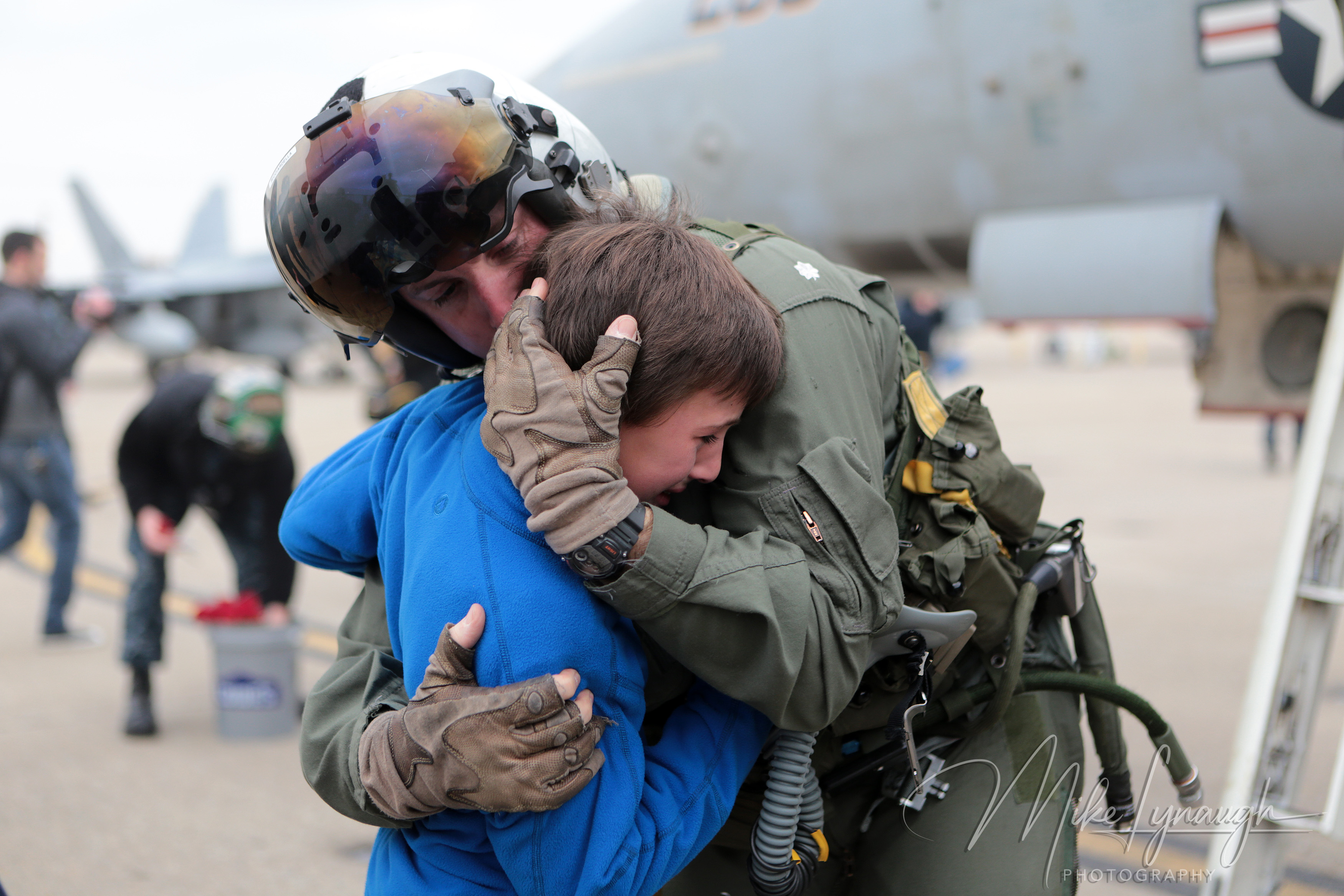 A returning naval aviator embraces his son during a military homecoming at NAS Oceana